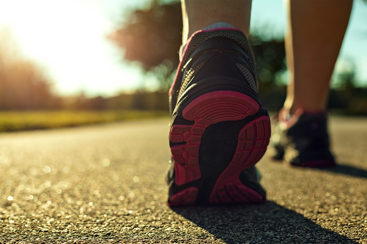 A closeup view of tennis shoes walking on a track on a sunny day