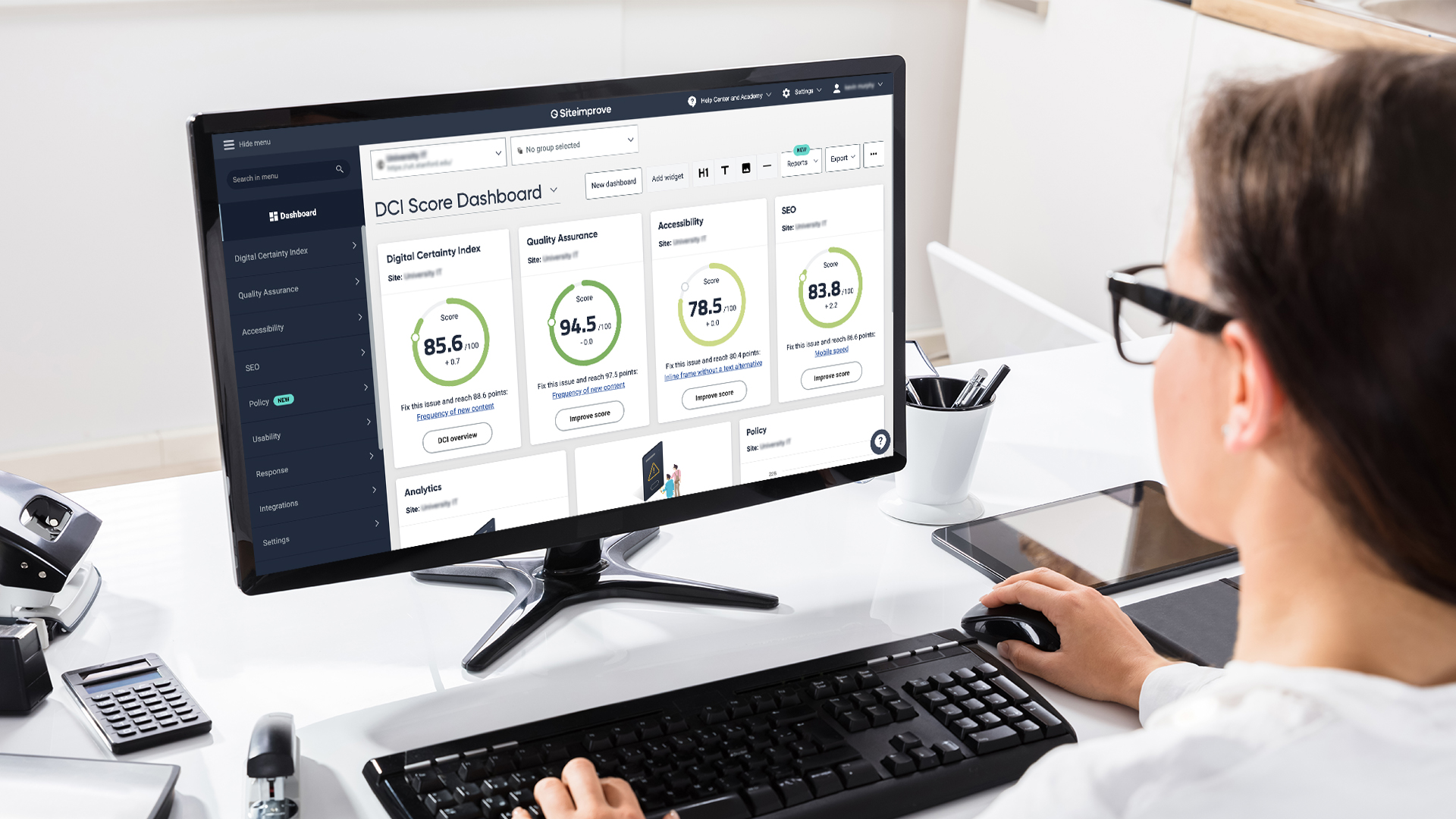 Person using a desktop computer with a Siteimprove dashboard on the screen