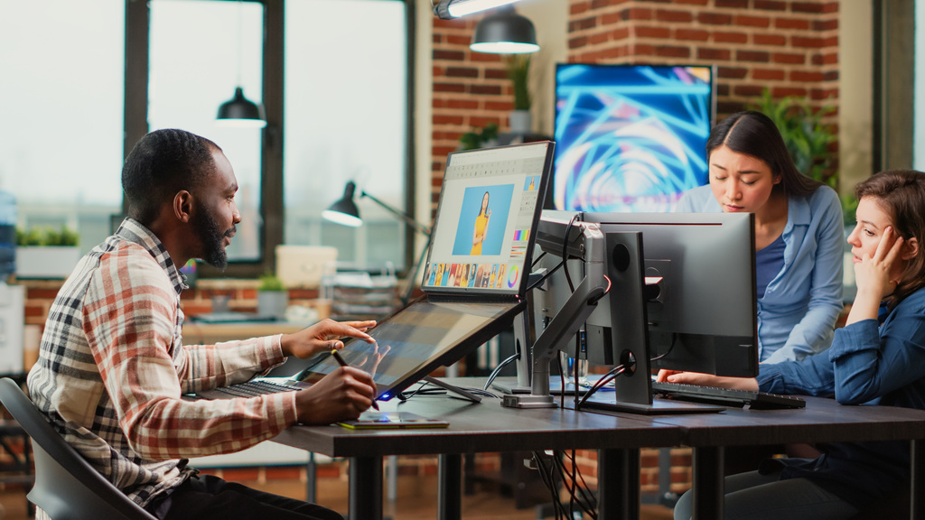 Coworkers in front of computers doing graphic design work