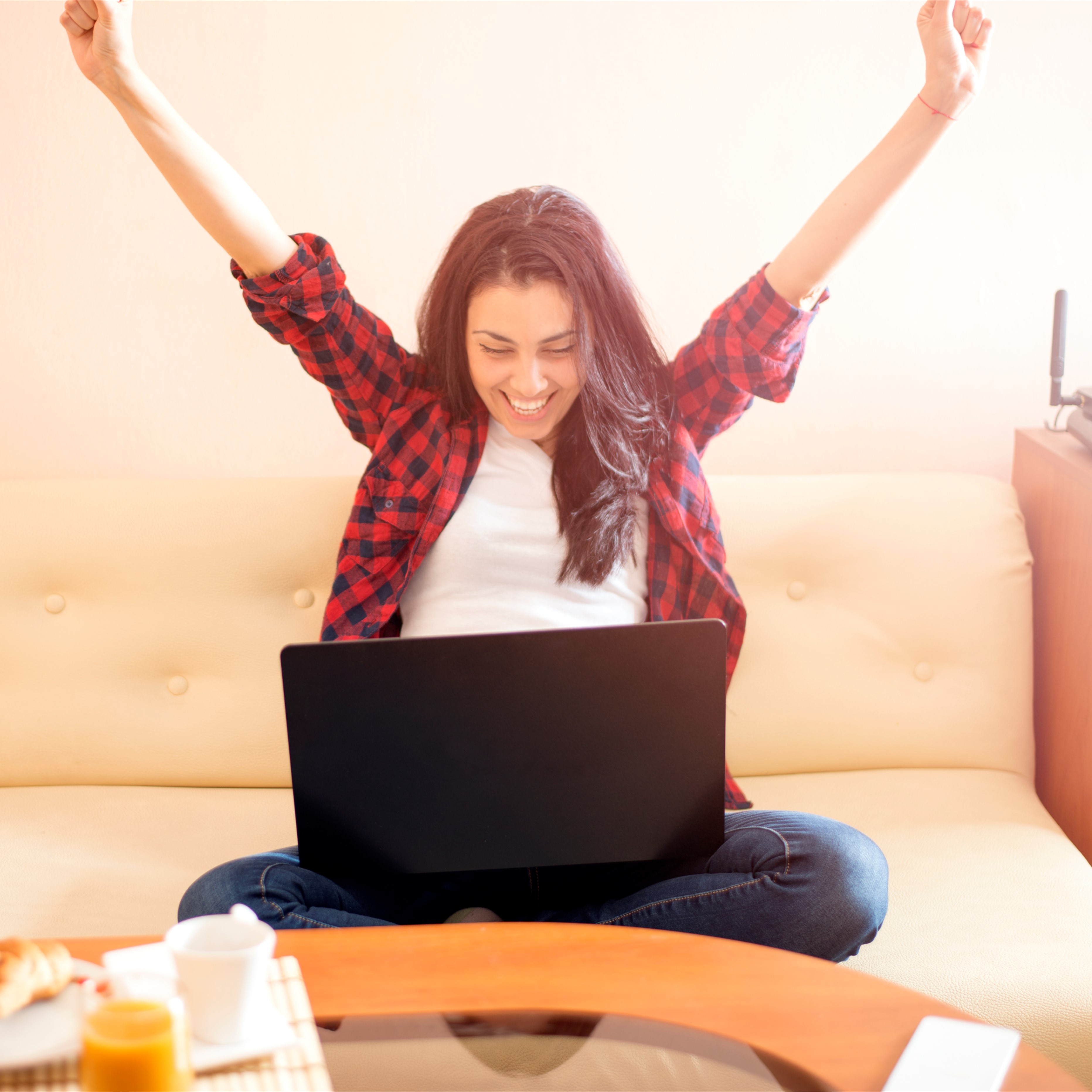 woman celebrating with laptop on lap