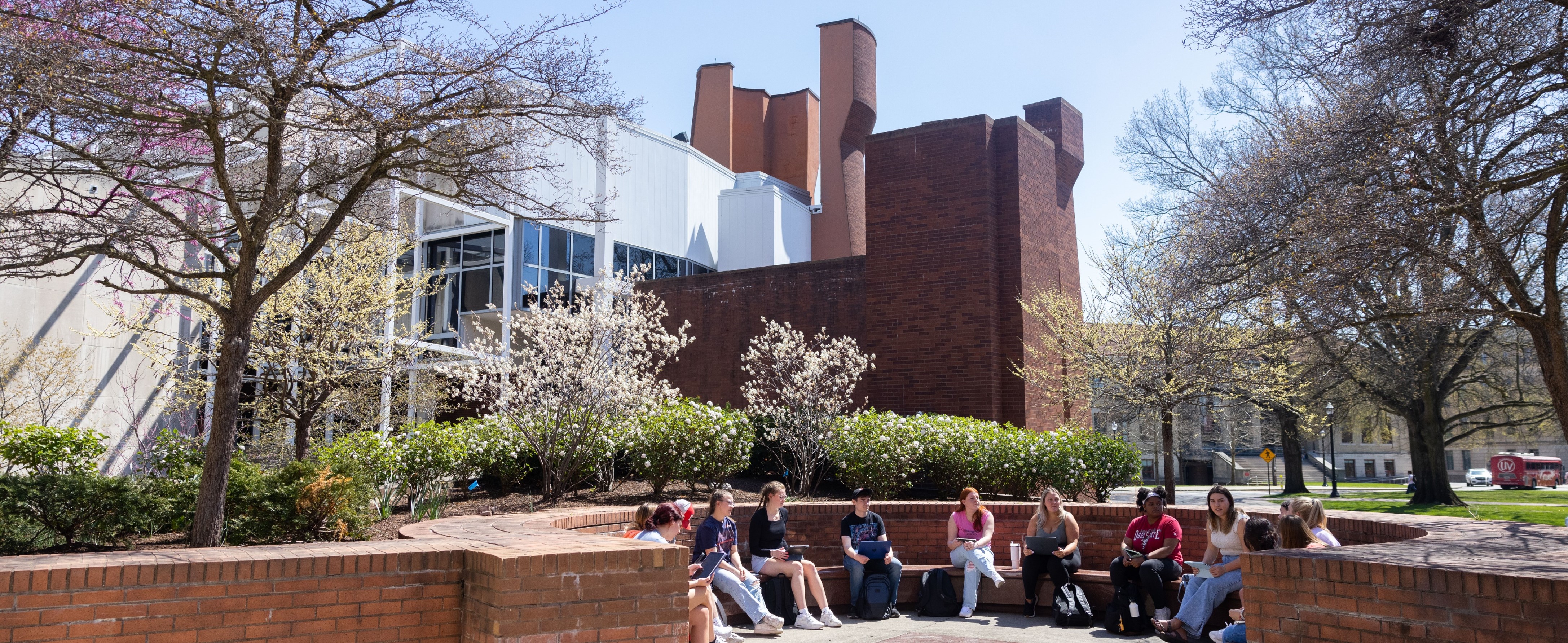 Students seated in front of the Wexner Center for the Arts in spring