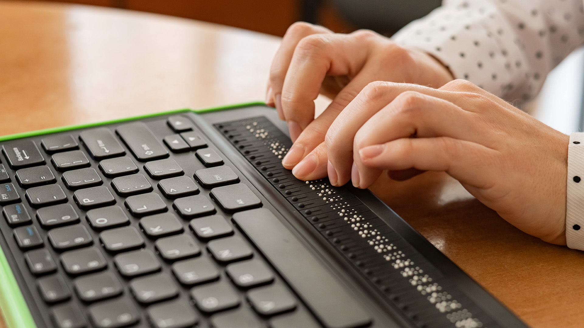 A blind woman using a Braille keyboard to interact with digital content