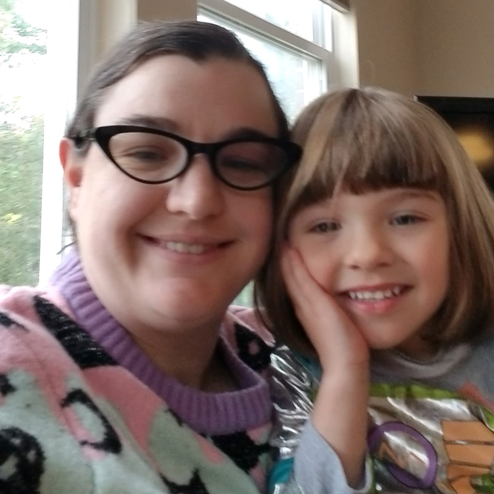 Mel and their daughter smile for the camera in a close up selfie.