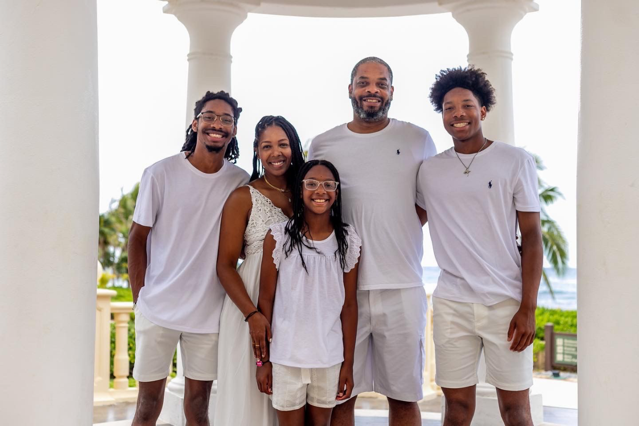 Portia, her husband, and her three kids pose for a picture during a beach vacation.