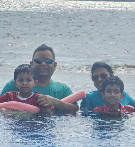 Marry, her husband, and their two sons swimming on a sunny day.