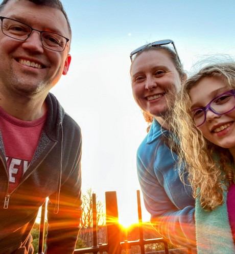 Tom, his wife and daughter pause for a sunrise snapshot on one of their many hikes.