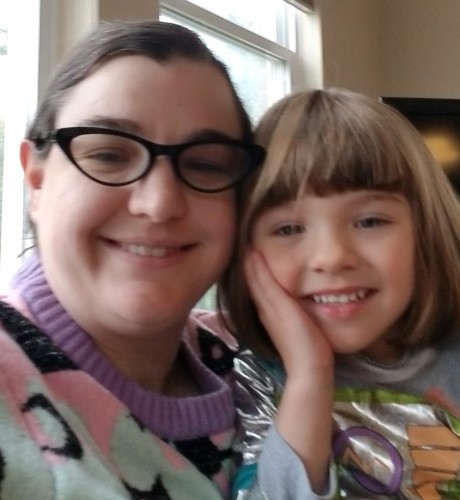 Mel and their daughter smile for the camera in a close up selfie.