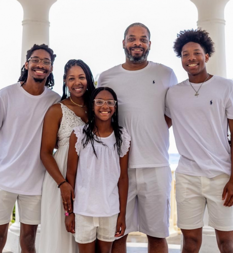 Portia, her husband, and her three kids pose for a picture during a beach vacation.