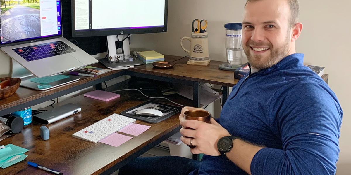 Todd Thomas sits at a computer desk in his home office
