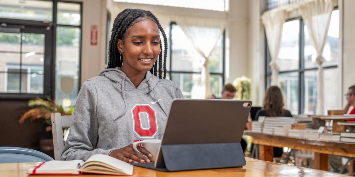 Student wearing a shirt with the Ohio State Block O using a tablet