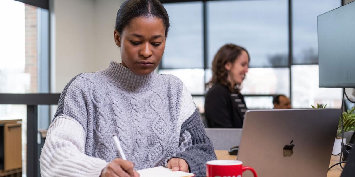 Woman writing while sitting at a desk