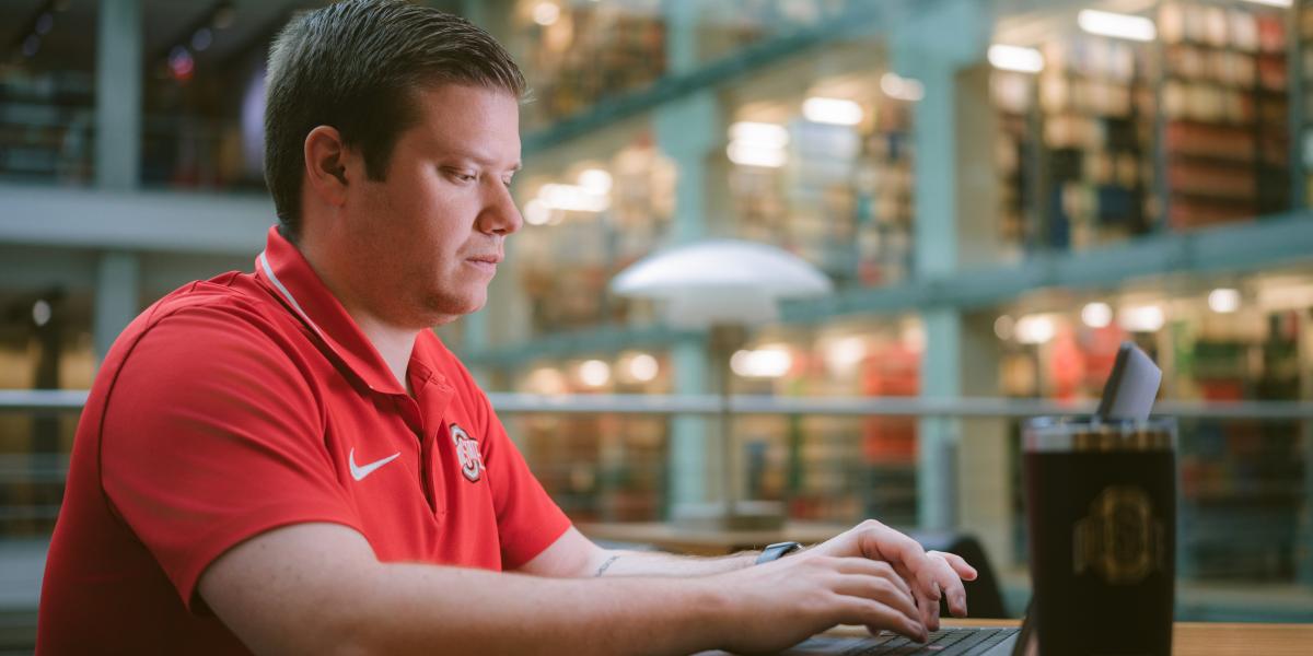 man on computer in library