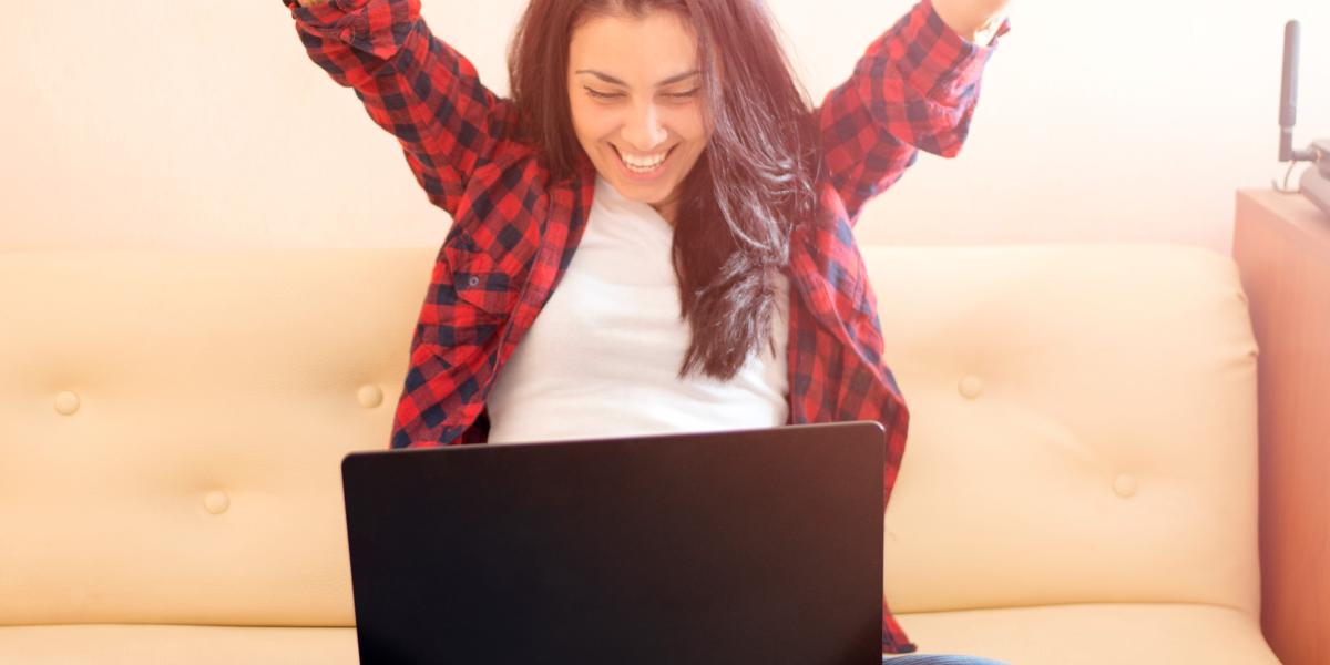 woman celebrating with laptop on lap