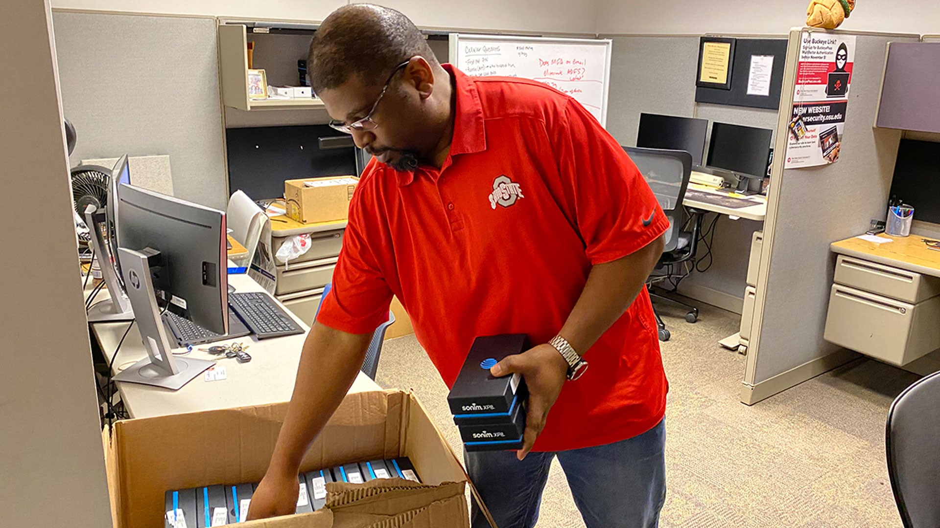 Ohio State IT Service Desk Manager Mario Morgan looks through a box of wireless hotspots