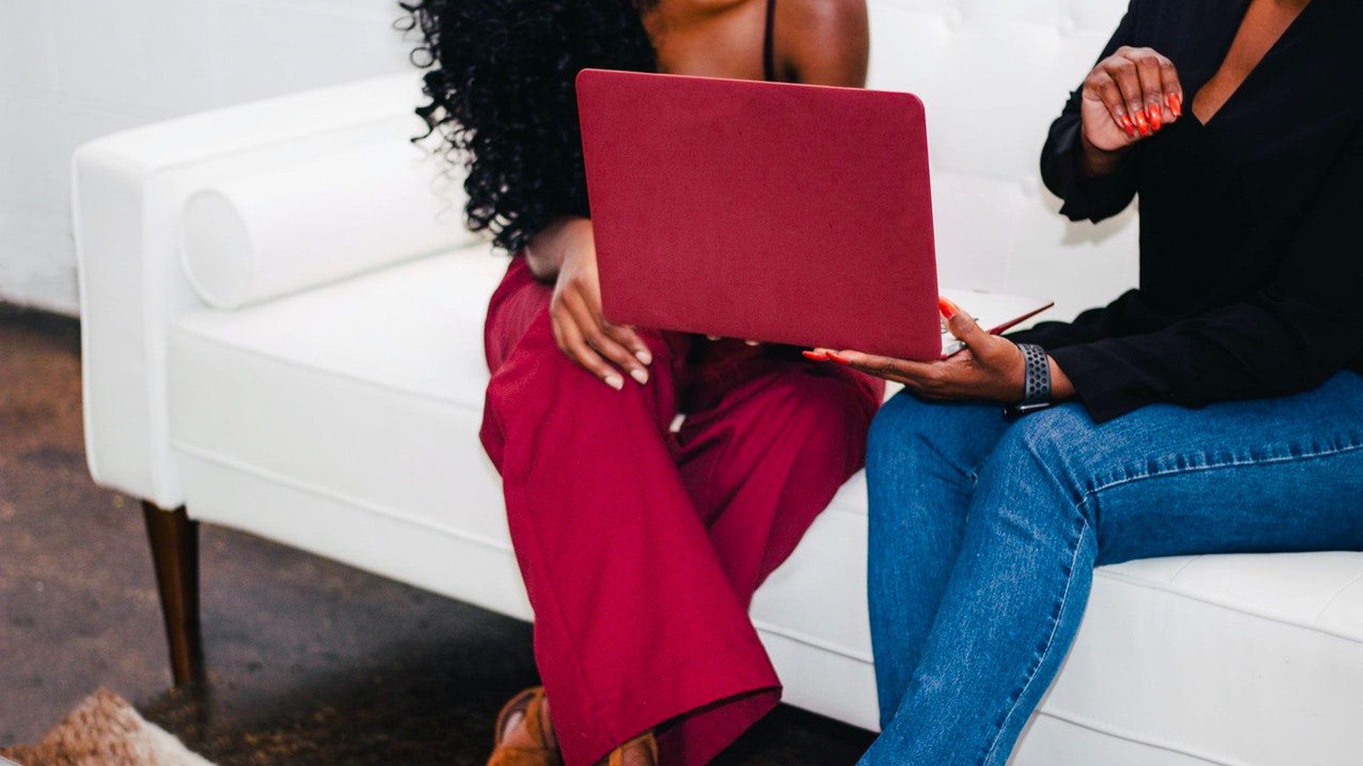 Two women of color looking at a laptop together