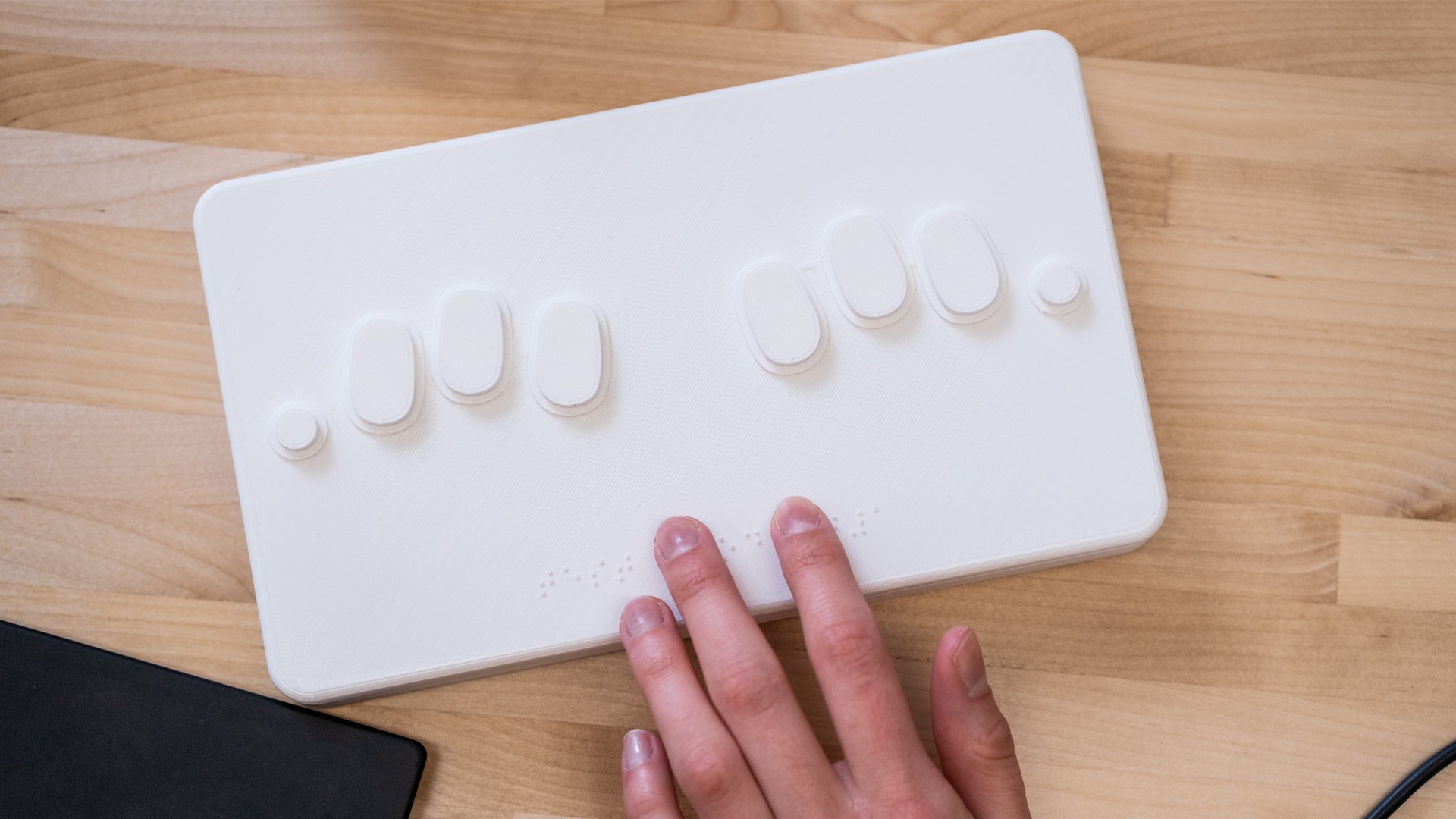 Hand using a braille keyboard