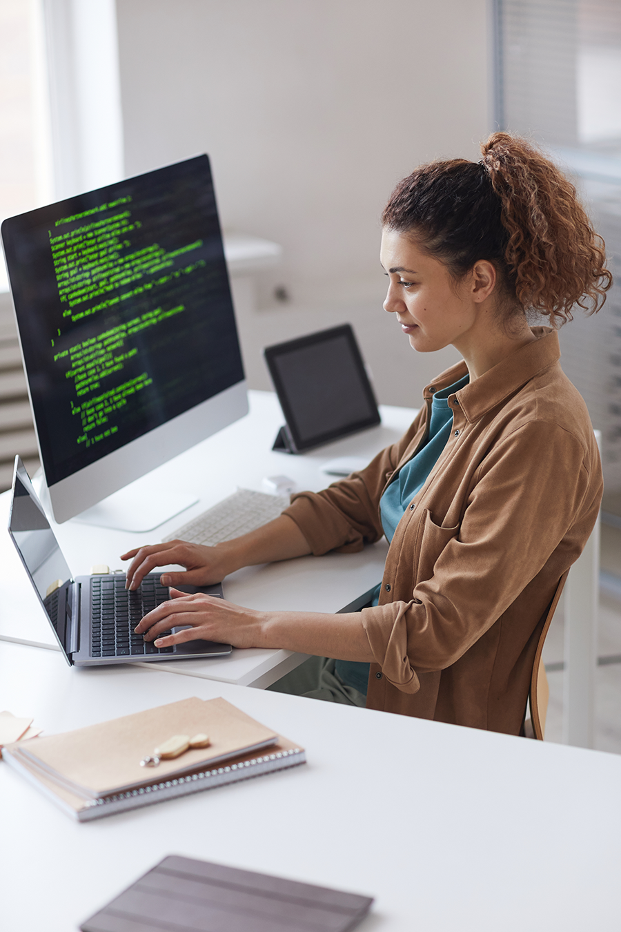 Woman working on a computer at a desk.