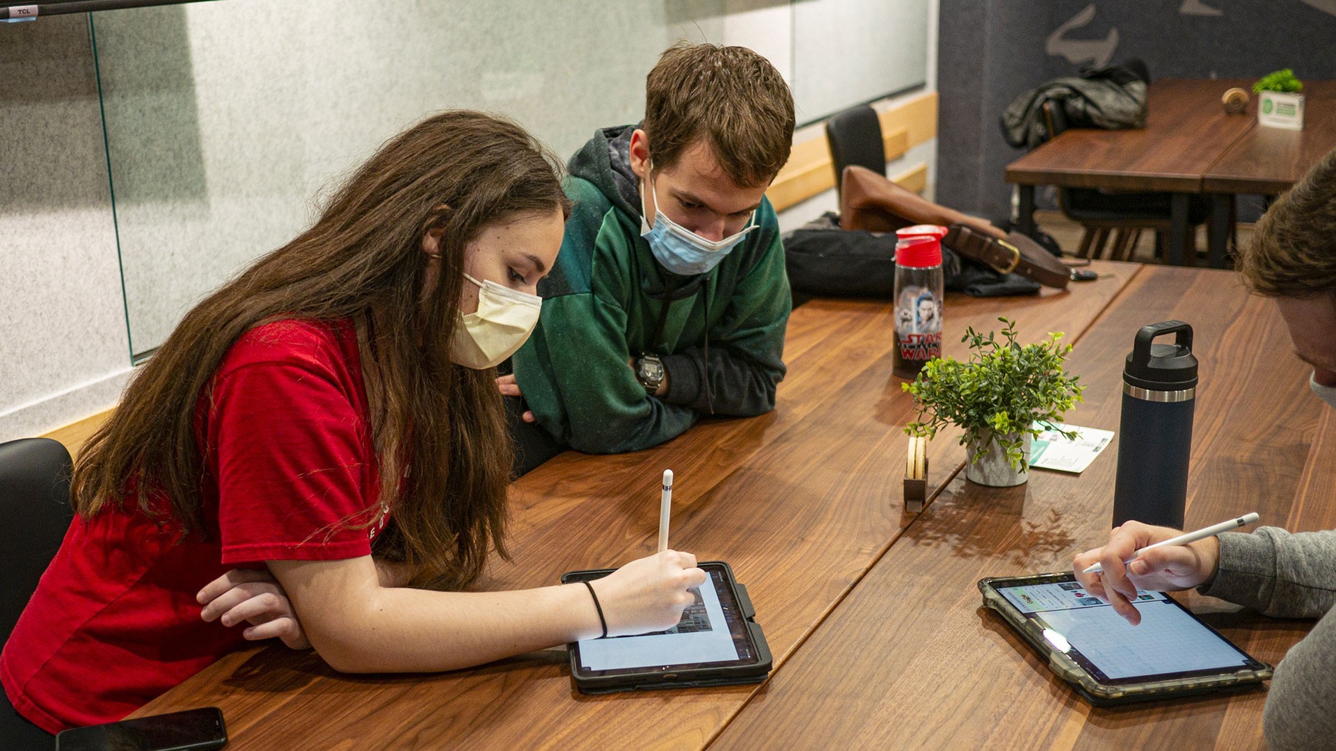 Students sitting at a table using iPads together