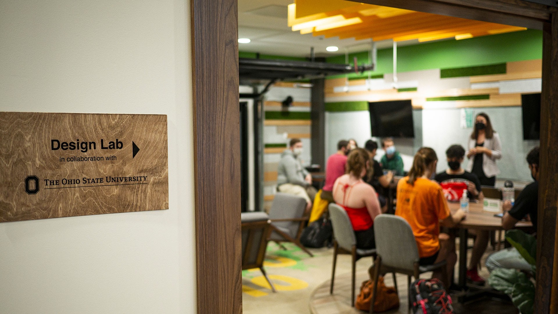 Design Lab sign outside of an open door with a workshop happening inside