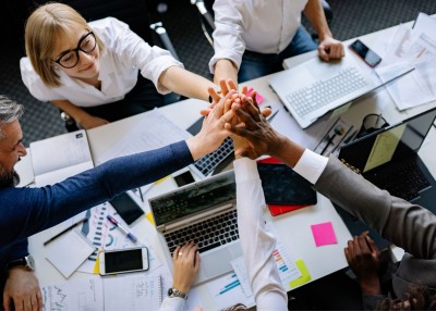 Diverse colleagues having a team building meeting with hands joined in center