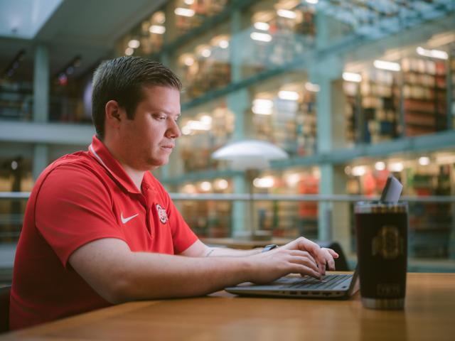 man on computer in library