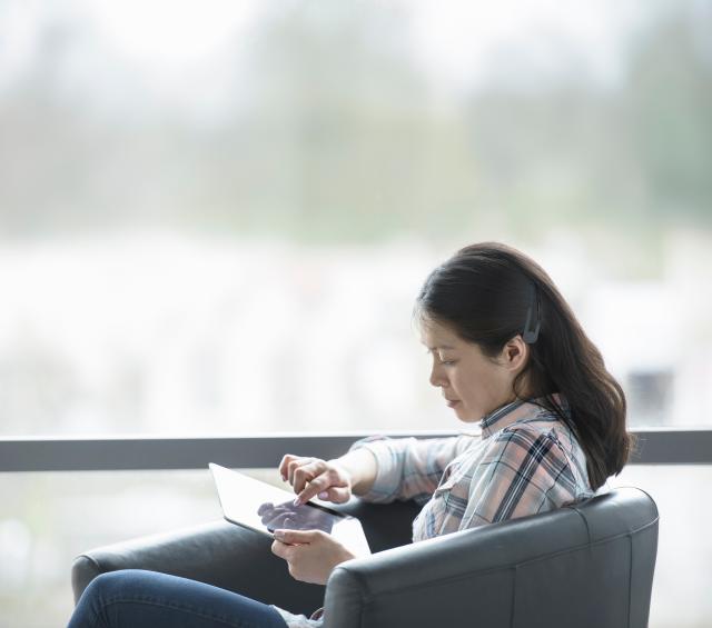 Decorative image of a woman using a laptop device.
