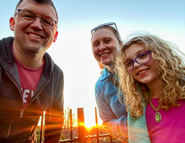 Tom, his wife and daughter pause for a sunrise snapshot on one of their many hikes.