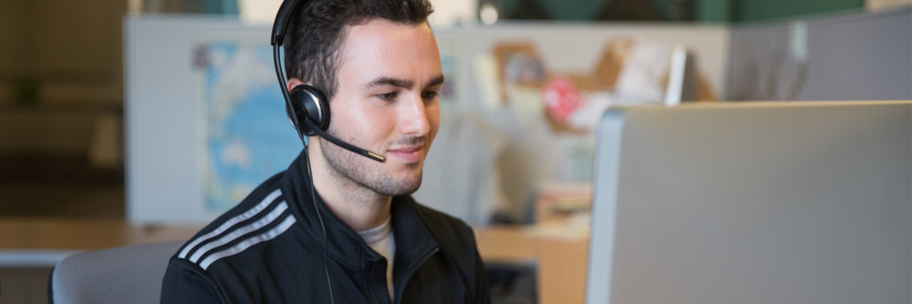 Call operator wearing a headset sitting in front of a computer