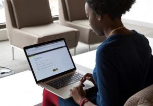 A woman sitting and using her laptop.